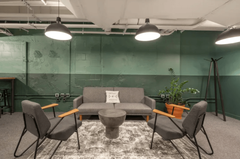 Gemütlicher Wartebereich mit Sofa, Sesseln und moderner Industrieoptik