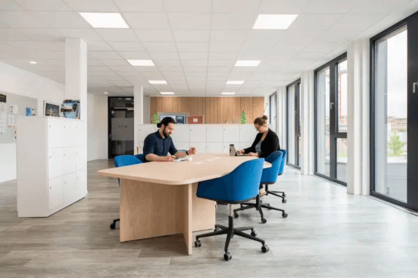Heller Arbeitsbereich in Kiel mit großem Gemeinschaftstisch und moderner Büroausstattung